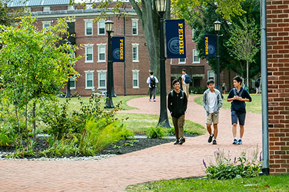 Students walking through campus. Links to Gifts by Will