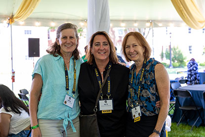 Three women stand close as they attend a Peddie event.