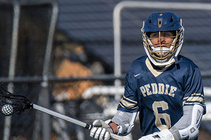 A student focusing on the lacrosse game. Links to What to Give