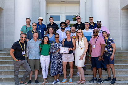 The class of 1999 stand in front of a school bulding.