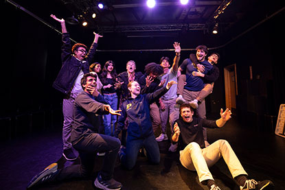 Students pose with their arms out as they act out a scene in a play. Links to Gifts of Life Insurance